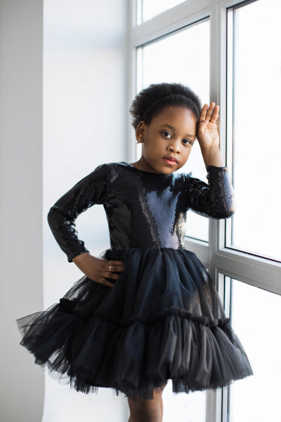 可爱的小女士在黑色裙子摆姿势在白色的工作室图片下载