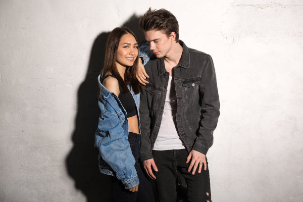 在灰色背景下微笑的年轻潮人情侣图片下载