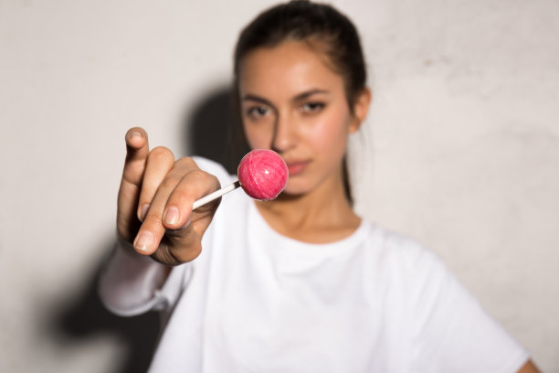 拿着糖果的潮女人。专注于糖果。图片下载