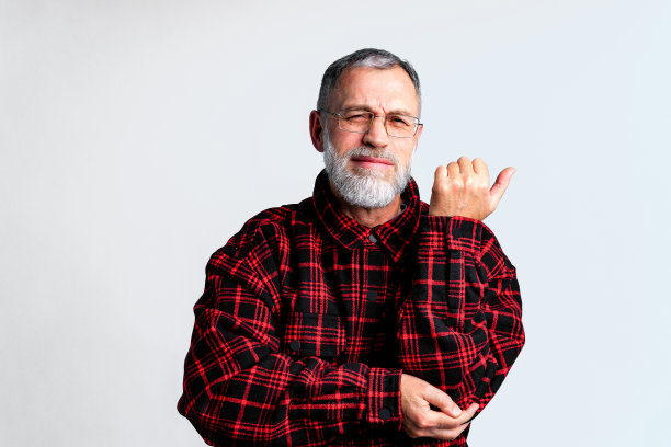 灰色背景下的成熟男人的肖像，遭受严重的身体疼痛，闭眼缓解疼痛图片下载