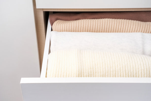 折叠的衣服在壁橱的特写，空间组织的概念。图片下载