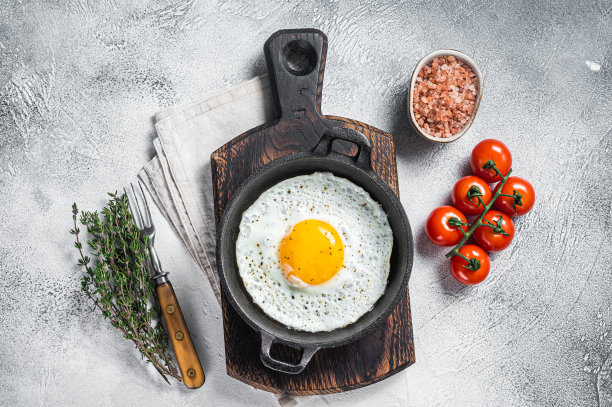 煎蛋加蕃茄、百里香及培根。白色背景。俯视图图片下载