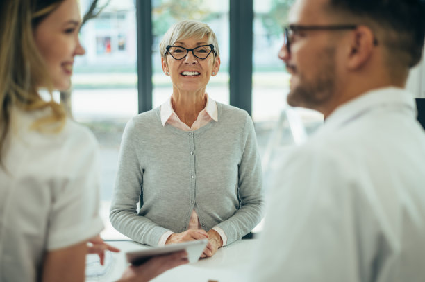 在一家药店里，两名药剂师给高级女性顾客开处方药图片下载