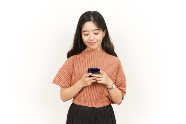 拿着和使用智能手机的美丽的亚洲妇女孤立在白色背景图片下载