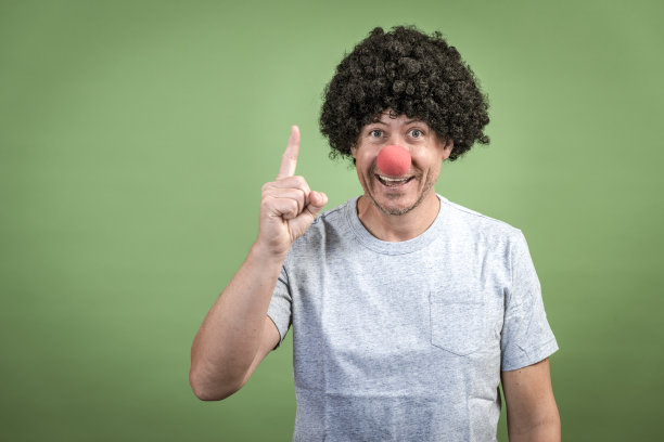 戴着黑色假发和红色小丑鼻子的男人图片下载