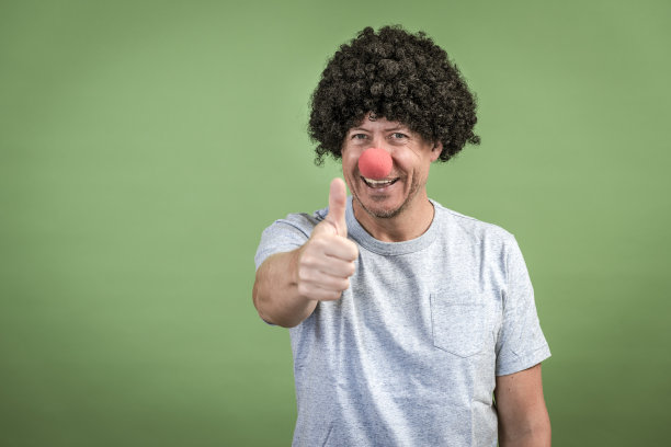 戴着黑色假发和红色小丑鼻子的男人图片下载