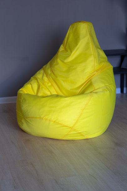 灰色墙壁的房间里有一把亮黄色的袋子椅图片下载