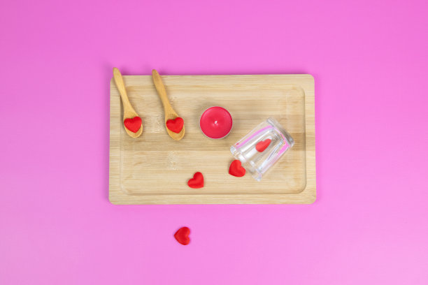 木板材。红色的心。粉红色的背景。情人节。香味蜡烛之类的礼物。浪漫的气氛图片下载