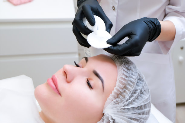 美容。可爱的年轻女子闭着眼睛接受面部清洁程序的特写照片图片下载