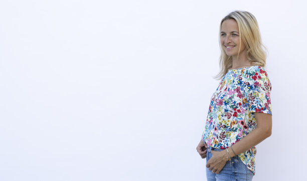 美丽的年轻女子金发摆姿势在白色背景前图片下载