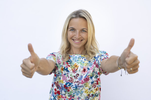 美丽的年轻女子金发摆姿势在白色背景前图片下载