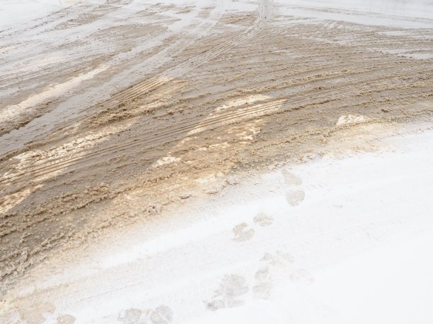 行人十字路口的雪、冰、雪泥和冬天的泥。气温在零度左右。困难的驾驶环境。汽车制动距离。交通法规。基础设施及道路服务图片下载