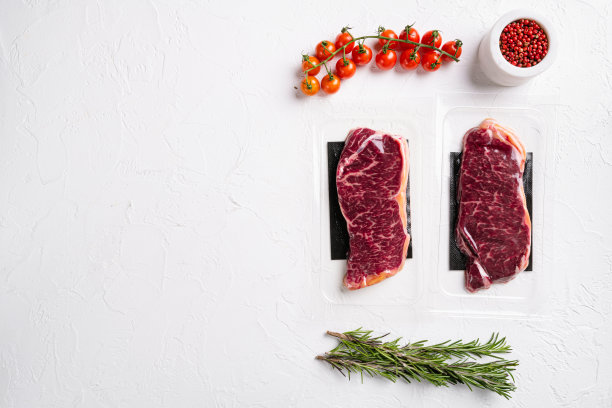真空包装生纽约striploin牛排，在白色石头桌子背景，俯视图平躺，与文本的复制空间图片下载