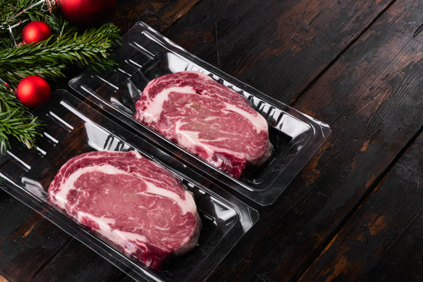 肋眼牛排包与圣诞树，在旧的深色木制桌子背景，与文本复制空间图片下载