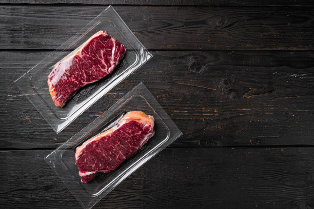 牛排包，在黑色木制桌子背景上，俯视图平躺，与文本复制空间图片下载