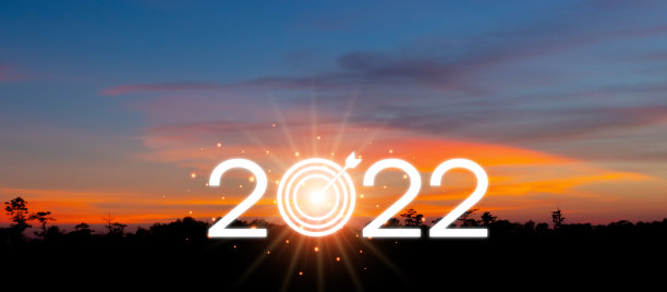2022年新年快乐，在美丽的夕阳、阳光、金色的天空和云彩成功的概念山上写着大型剪影字母。2022年欢迎圣诞快乐和新年快乐。图片下载