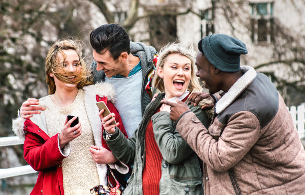 多文化群体的千禧朋友走在伦敦市中心-友谊和生活方式的概念，快乐的年轻人在冬季时装衣服有乐趣的一天在一起-对比滤镜图片下载