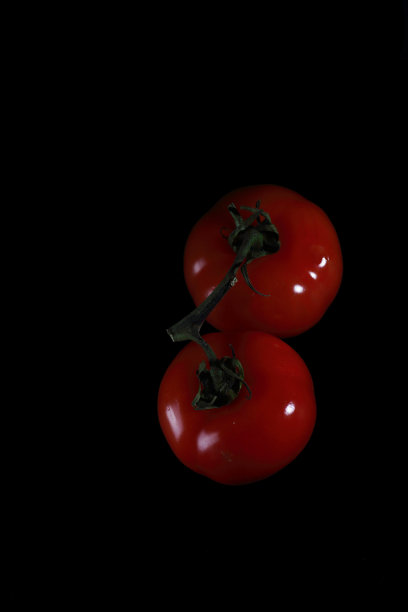 两个红番茄孤立在黑色背景平躺。图像包含复制空间图片下载