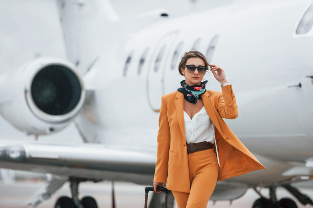 多云的天气。女乘客穿着黄色衣服，戴着太阳镜，带着行李图片下载
