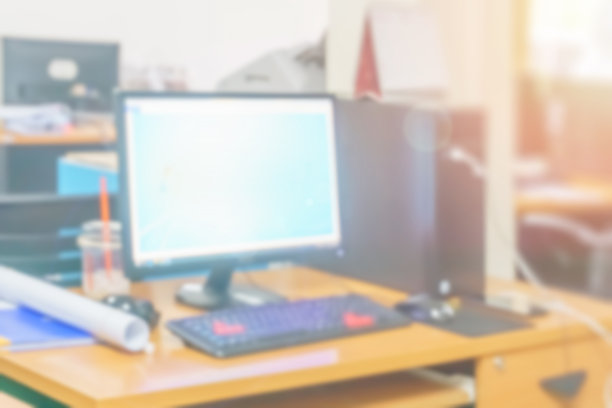 模糊办公电脑在办公桌上忙碌的室内建筑，商业背景与企业信心的形象，抽象的办公人员和工作场所模糊的技术。图片下载