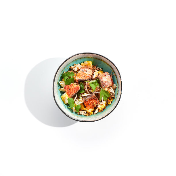 亚洲传统菜肴-鸡蛋，蔬菜和鲑鱼炒饭。泛亚炒锅，白色底色，配米饭，鸡蛋和鱼。三文鱼炒饭在阴影的孤立背景上。图片下载