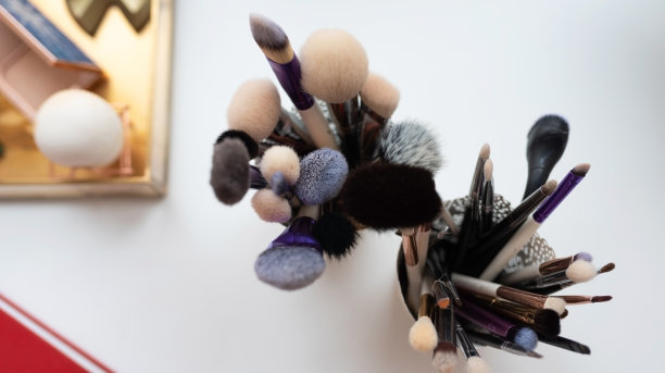 不同尺寸的化妆刷，放在玻璃杯里。图片下载