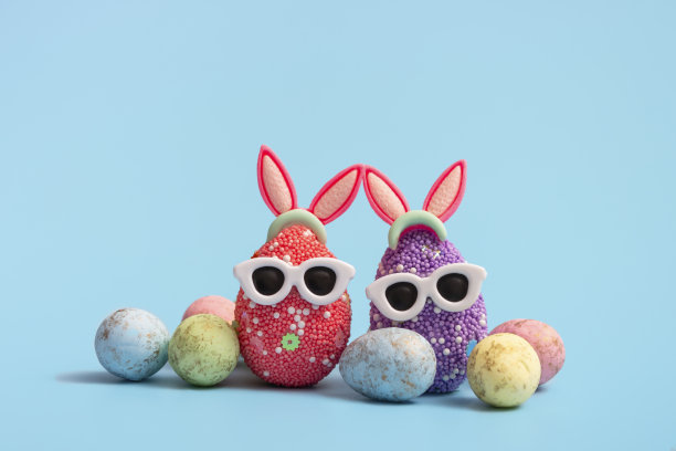 色彩丰富的复活节彩蛋与兔子耳朵和太阳镜在蓝色的背景。销售横幅，模型模板。本空间图片下载