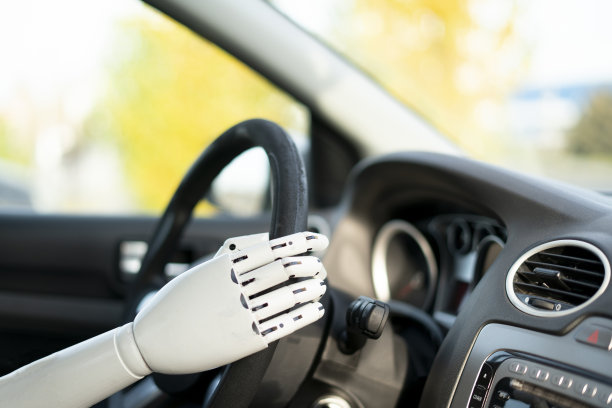 人工机械白臂握着方向盘驾驶车辆图片下载