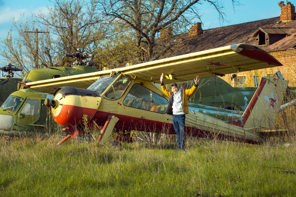 一个年轻人站在一架废弃的苏联旧飞机前。这家伙喜欢学习古老的技术图片下载