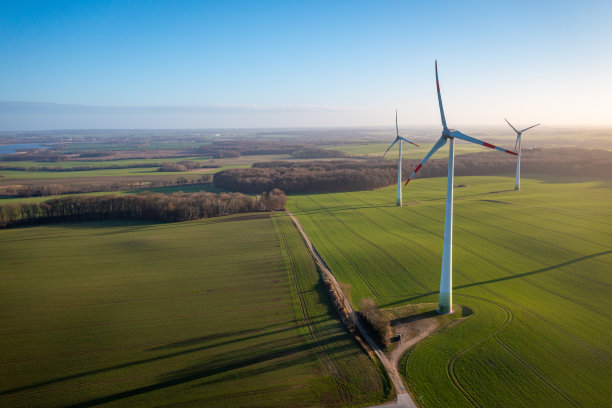蓝天下，一些白色的风力涡轮机在风中旋转图片下载