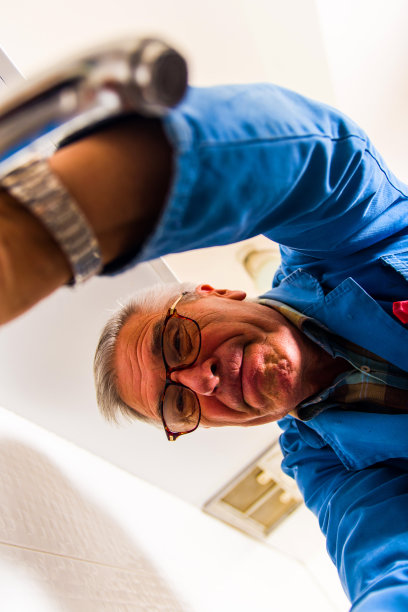 修理厨房水龙头的成熟工人图片下载