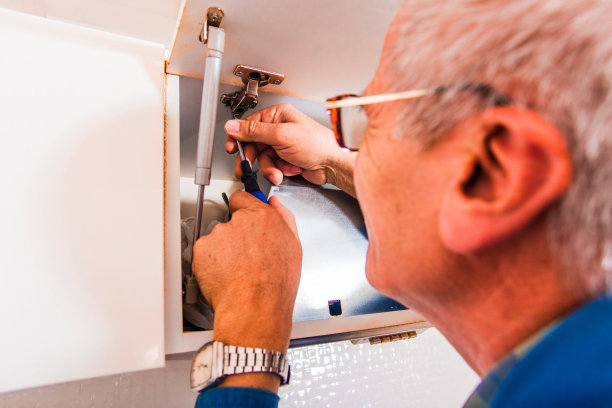 工人在厨房修理碗柜图片下载