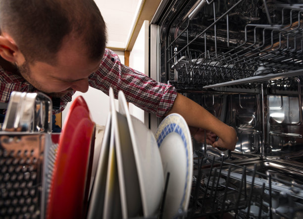 杂工修理厨房里的洗碗机图片下载