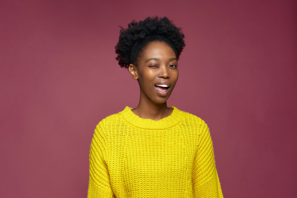 时尚积极乐观的年轻非洲裔美国女孩眨眼，调情，有好主意，工作室头照图片下载