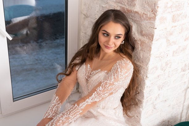 窗台上长发飘逸的新娘。图片下载