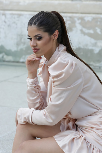 美丽的年轻女子的户外肖像与长马尾辫优雅的缎子连衣裙图片下载