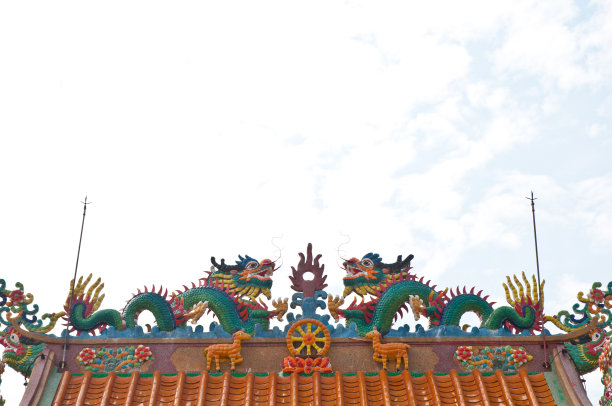在一座寺庙的屋顶上，两尊玉绿艺术巨龙雕像图片下载