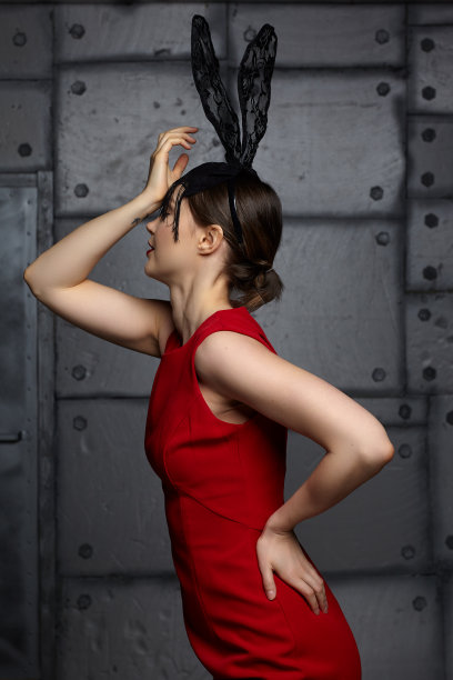 年轻女子在黑色兔子或野兔花式面具和红色的连衣裙。图片下载