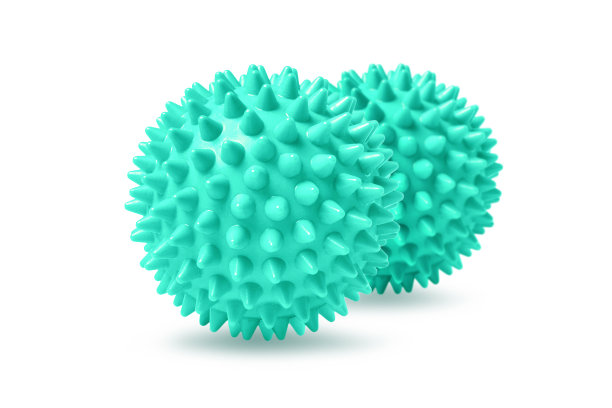 两个绿色带刺的按摩球隔离在白色上。理疗或健身的概念。一个彩色橡胶球的特写狗牙齿在白色的背景。冠状病毒模型图片下载