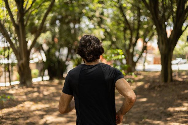 一个在户外公园跑步的年轻人。男运动员在锻炼时。高质量的照片图片下载