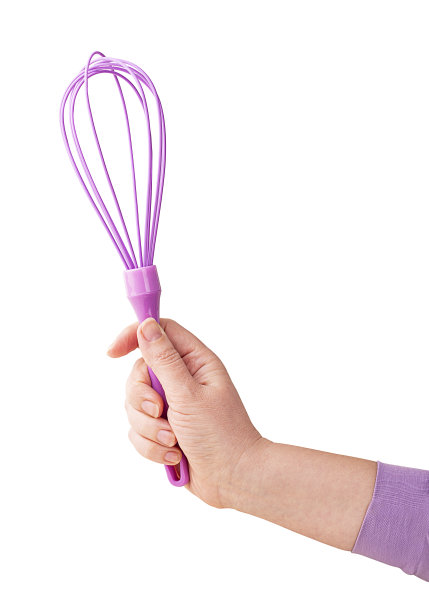 一个女人手里拿着粉红色的厨房搅拌器图片下载