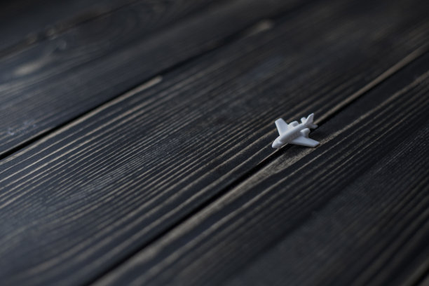 黑色木板背景上的白色玩具飞机图片下载