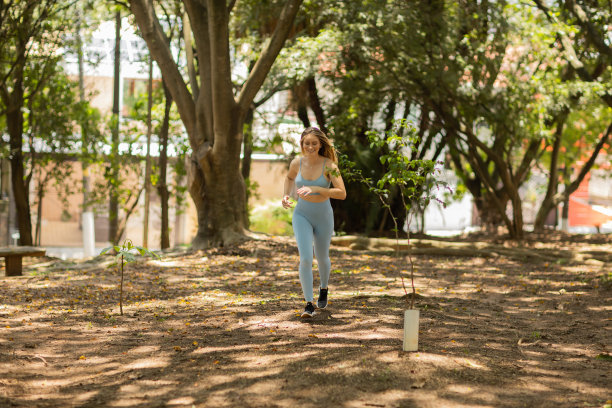 一个在户外公园跑步的年轻女子。女运动员在锻炼时。高质量的照片图片下载