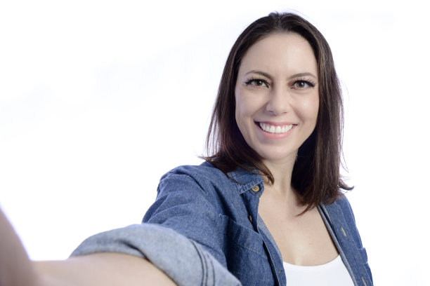 年轻女子看着手机自拍图片下载