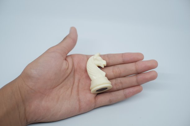 有人的手拿着一个骑士的棋子图片下载