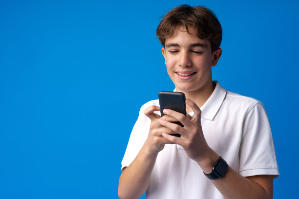 青少年在用蓝色背景的手机图片下载