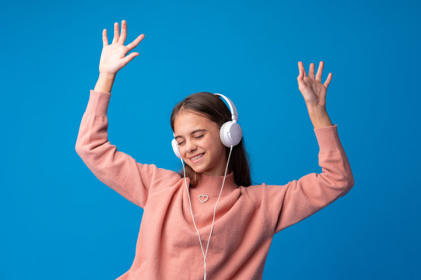 戴着耳机的女生在蓝色背景下听音乐图片下载