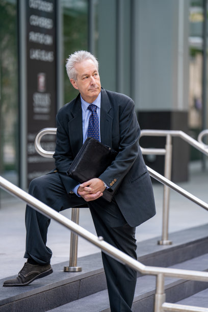 帅气的商人穿着西装在楼梯上摆姿势图片下载