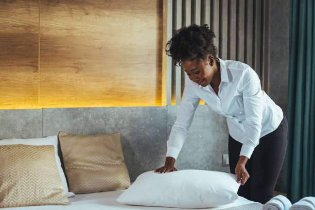 在旅馆里整理床铺和枕头的女佣。图片下载