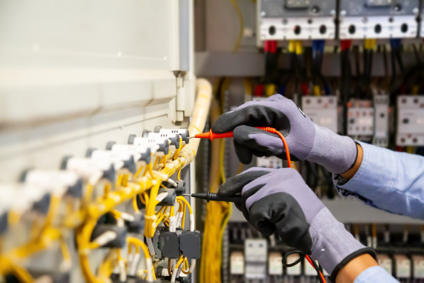 电气工程师使用数字万用表测量设备检测主配电板断路器和电缆接线系统的电流电压。图片下载